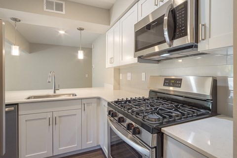 a kitchen with white cabinets and stainless steel appliances